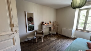 Quarto com cama, poltrona, lareira, radiador e janela.