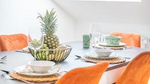 Ein Esstisch mit einer Ananas, einer Traubenschale und einem Glas Wasser.