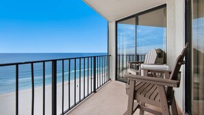 A balcony with a view of the beach and ocean.