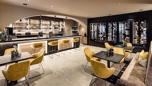 Un espace bar moderne doté d’un comptoir incurvé, de tabourets de bar et d’un présentoir à bouteilles.