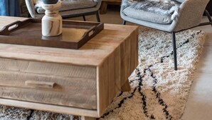 A cozy living room with a stone wall, wooden furniture, a large TV, and a fluffy rug. - Olvera 203 - New apartment at the foot of the slopes (VALMEINIER)