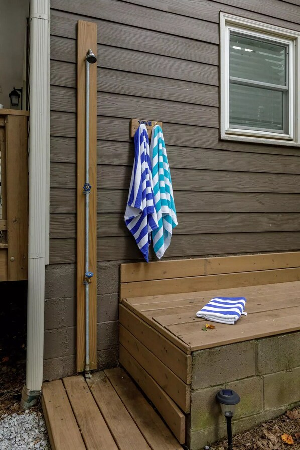 A wooden bench with a towel and a metal pipe against a wooden wall.