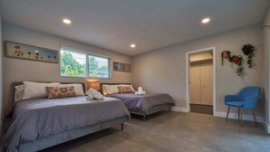 A bedroom with two beds, a chair, and a door leading to another room. - Villa Athena • Basketball Court | Heated Pool (Miami)