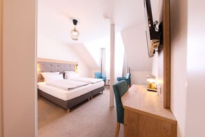 A modern hotel room with a large bed, a desk, and a chair. - 247 selfcheckin Schmiedestrasse (Leer)