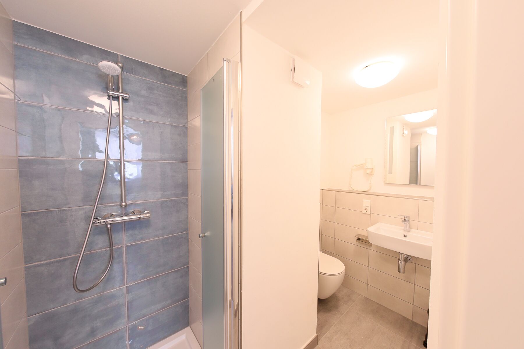 A bathroom with a shower, toilet, and sink.