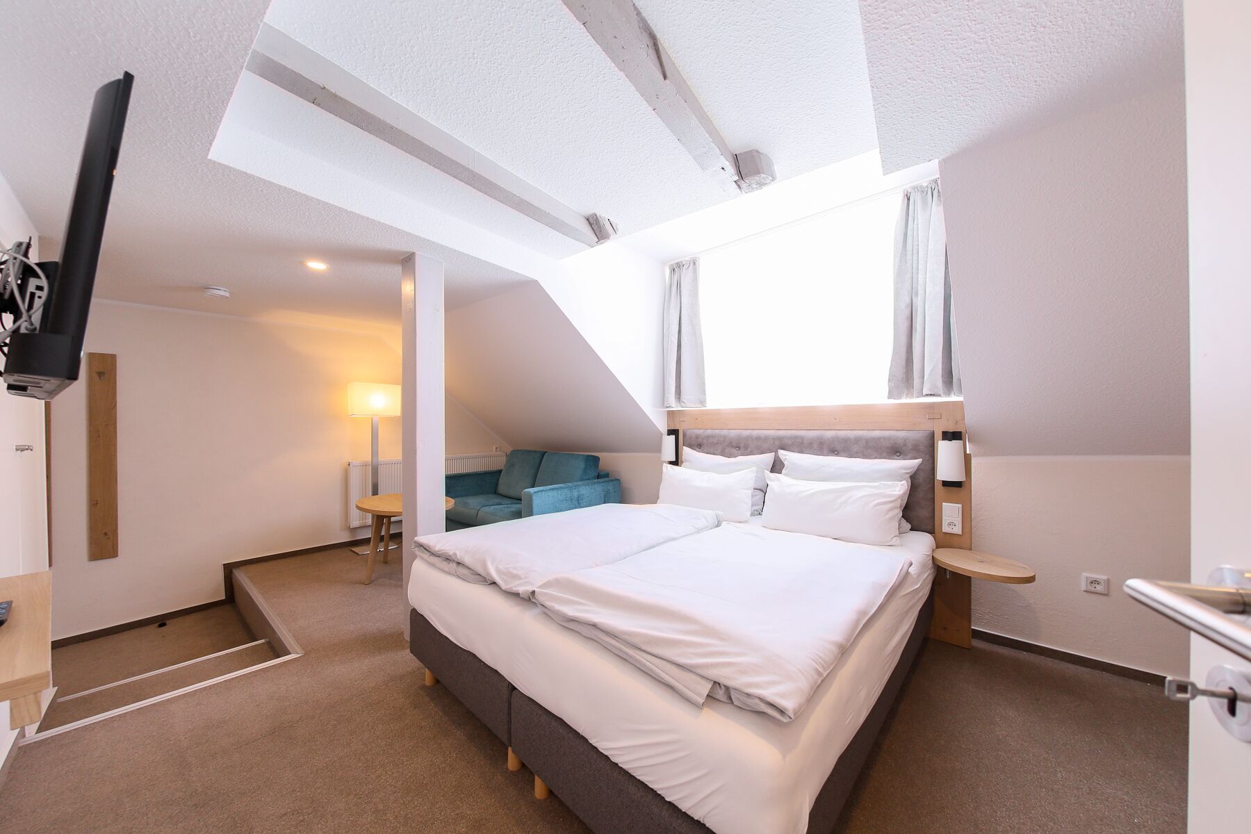 Une chambre d’hôtel moderne avec un grand lit, un canapé et un bureau.