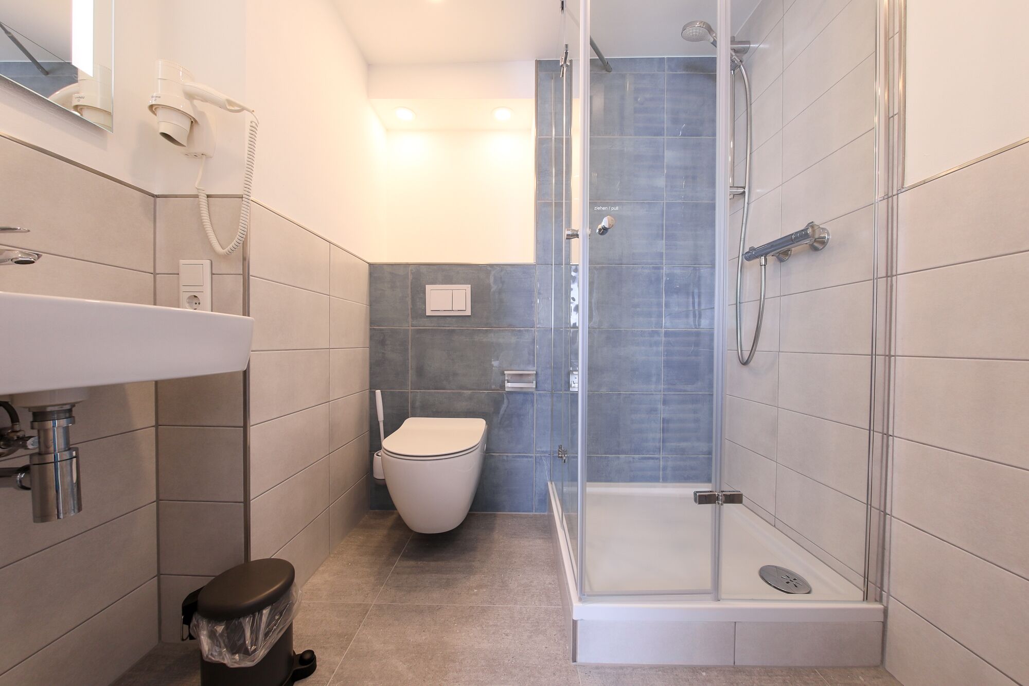 Un baño moderno con inodoro, lavabo y ducha.