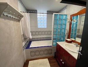 Bathtub, hair dryer, towels, toilet paper
