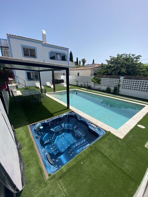 A modern house with a swimming pool and a hot tub.