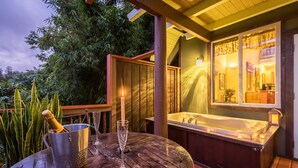 A wooden deck with a jacuzzi, a metal bucket, and two glasses. - Mahina Cottage, Mahina Cottage (Maui County)