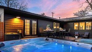 Un espace avec un bain à remous, une table et des chaises, un radiateur et une vue sur le ciel.
