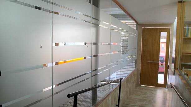 A modern hallway with glass partitions, a wooden door, and a metal handrail. - Bet Hotel (Buenos Aires)