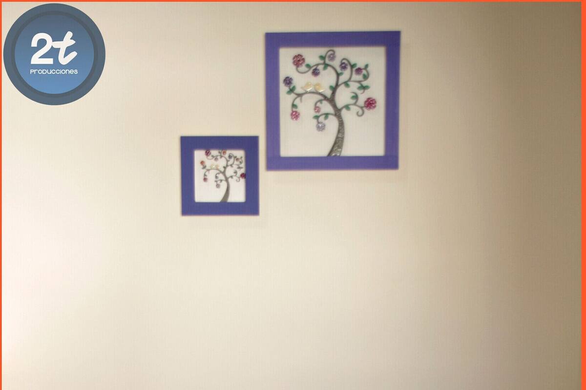 Una habitación de hotel con una cama, dos cuadros en la pared y una mesita de noche con una lámpara.