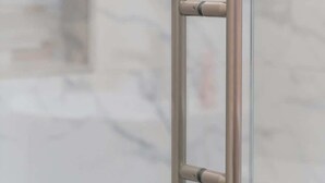 Une salle de bain dotée d’une douche à parois de verre et d’un mur en marbre.