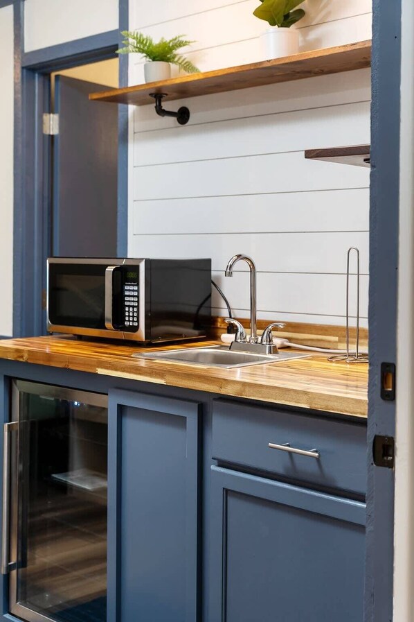 Microondas, cafetera y tetera, utensilios de cocina y toallas de papel 