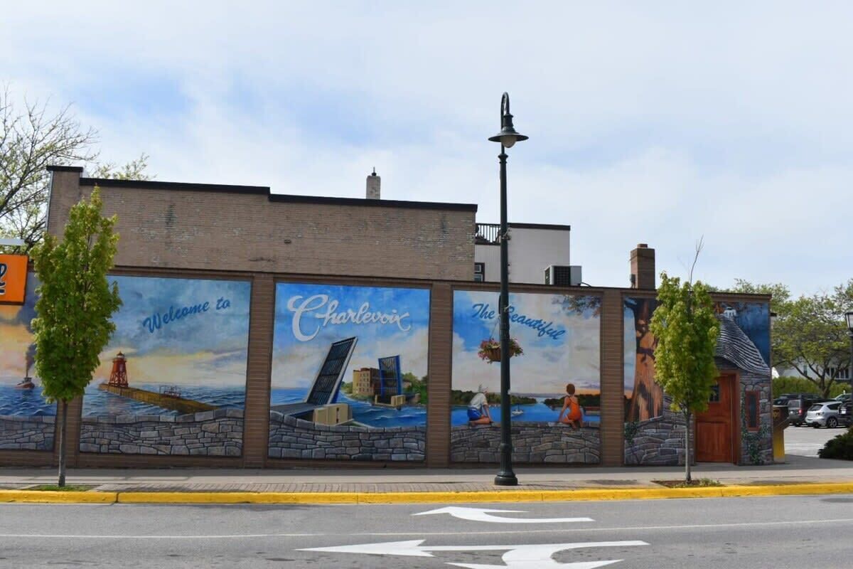 A mural on a building with the words "Welcome to Charlevoix" and "The Beautiful."