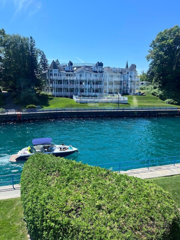Un hôtel situé au bord de l’eau, doté de nombreux balcons, d’un quai et d’un bateau.