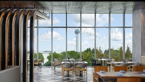 A modern restaurant with large windows, wooden furniture, and a view of a cityscape. - Renaissance Changzhou Wujin Hotel (Changzhou)