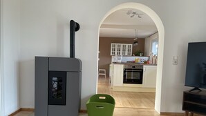Une cuisine moderne avec des meubles blancs, un four encastré et un coin repas comprenant une table et des chaises.