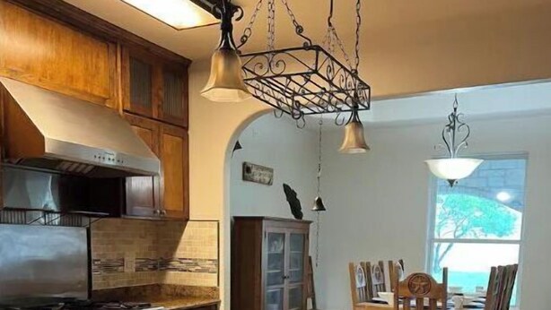 A kitchen with wooden cabinets, a stainless steel stove, a large island, and pendant lighting. - Spacious 4 br getaway. Riviera Beach / Baffin Bay (Riviera)