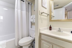 A bathroom with a bathtub, toilet, and sink. - Oceanfront Balcony Views, Pool, STEPS to Beach, Restaurants, Shops (Wrightsville Beach)