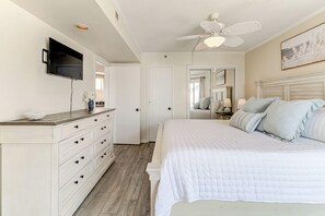 A bedroom with a bed, a dresser, a television, and a ceiling fan. - Oceanfront Balcony Views, Pool, STEPS to Beach, Restaurants, Shops (Wrightsville Beach)