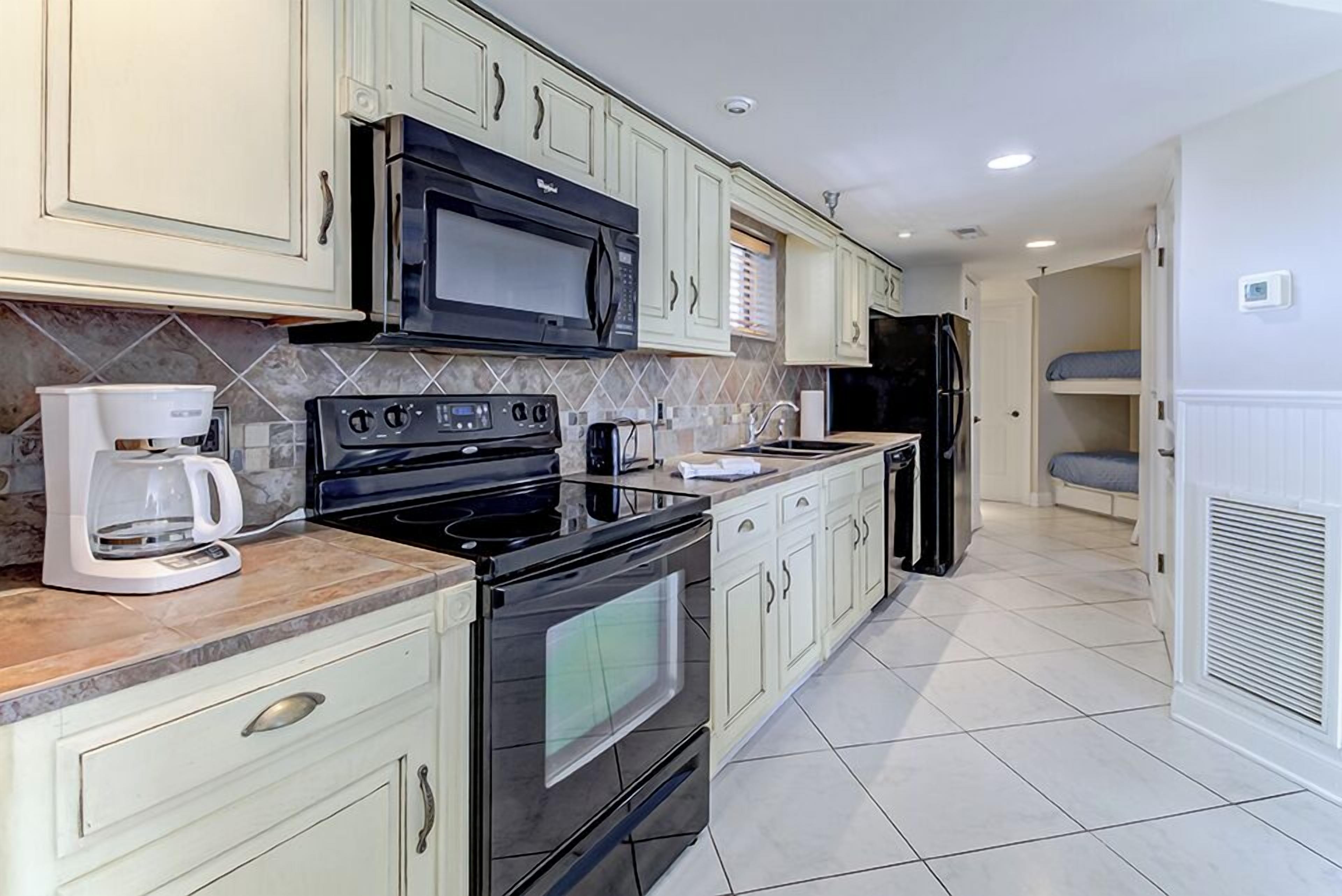 Una cocina equipada con estufa, microondas, horno y refrigerador.