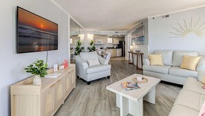 Ein modernes Wohnzimmer mit Sofa, Couchtisch und Fernseher.