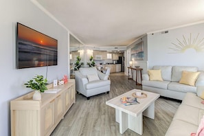 A modern living room with a sofa, coffee table, and a TV.