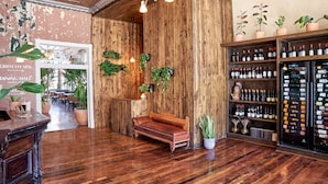 A wooden interior with a bench, potted plants, and wine bottles on shelves. - Western Hotel Ouray (Ouray)