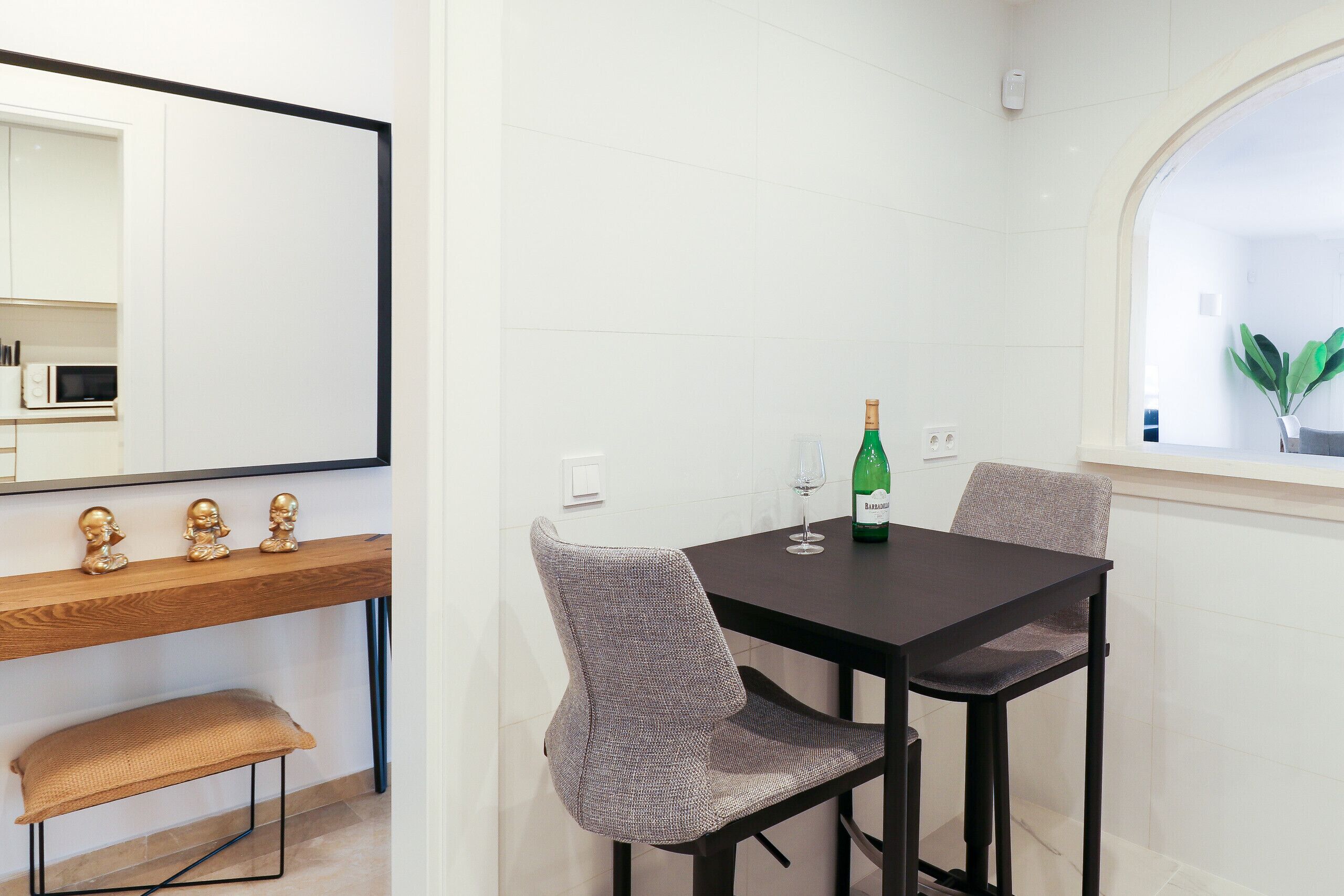 A dining area with a wooden bench, a table, and two chairs.