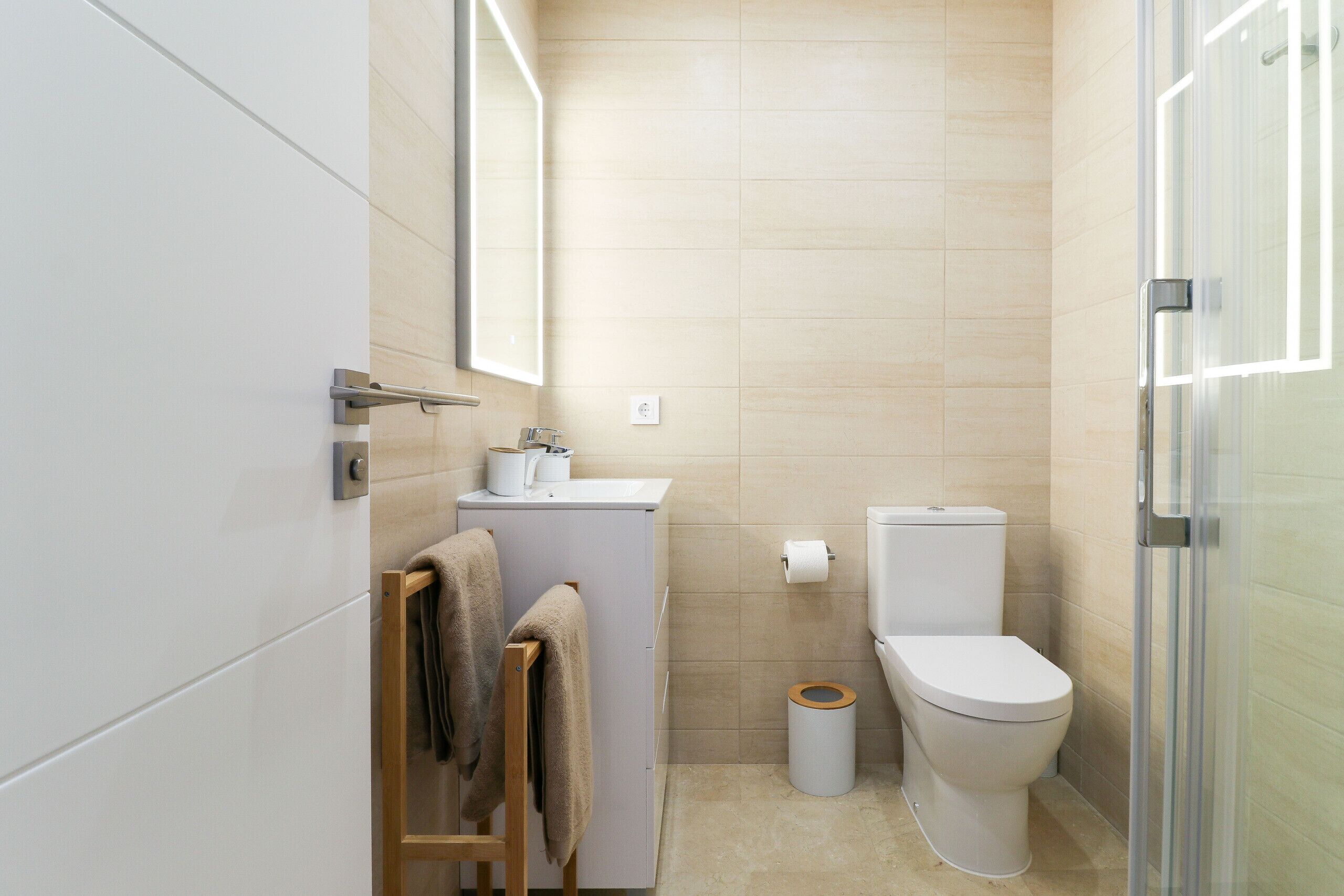 A modern bathroom with a toilet, sink, and mirror.