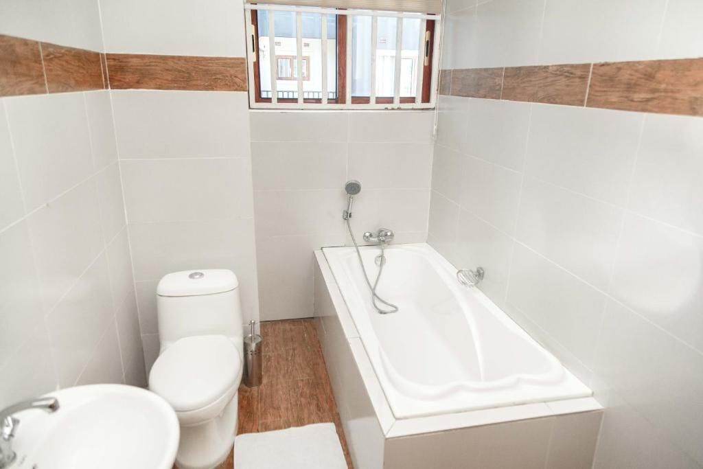 A bathroom with a toilet, sink, and bathtub.