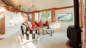 Una sala de estar acogedora con chimenea, sofá, mesa de centro y televisor.