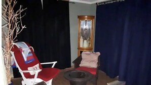 En stue med pejs, to lænestole, en sofa og et sofabord.