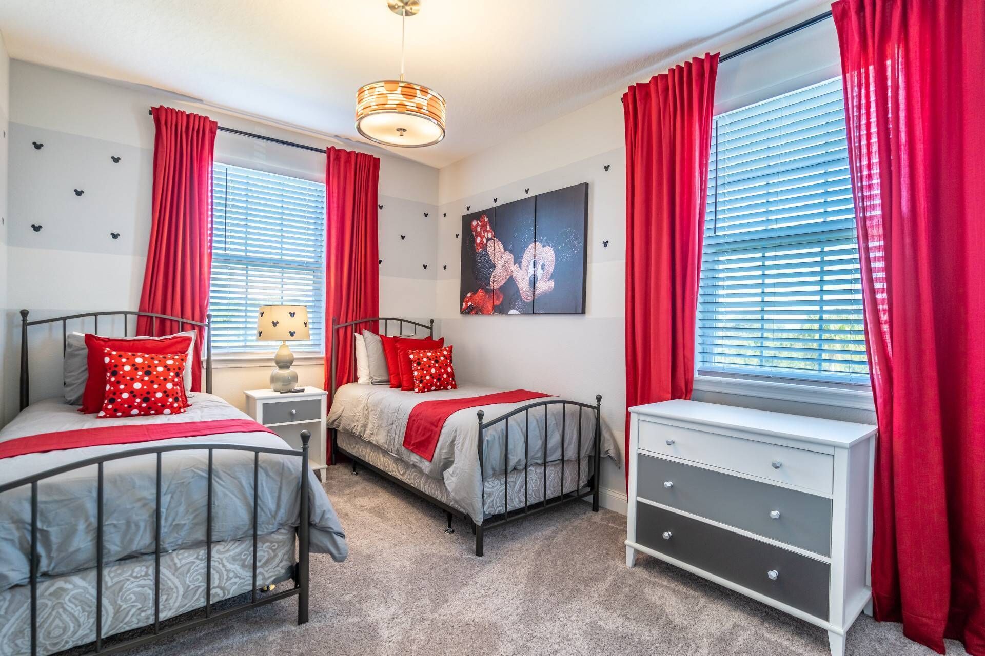 A bedroom with two beds, a nightstand, a dresser, and a wall art piece.