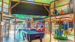 An indoor recreational area with a pool table, arcade games, and a carousel. - 727 Regal Palms (Davenport)