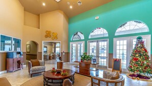 A spacious lobby with a large Christmas tree, comfortable seating, and a view of the outside through large windows. - 4552 Bella Vida 2 (Kissimmee)