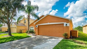 A residential house with a garage, a driveway, and a well-maintained lawn. - 17637 Silver Creek (Clermont)