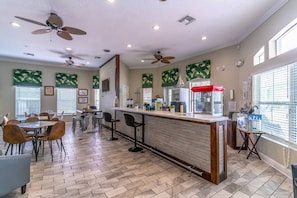 Relax in this stylish room with a central bar area, dining space, and large windows.