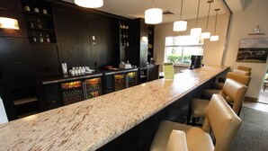 A bar area with a marble countertop, bar stools, and a variety of beverages in the fridge. - 3088 Encantada (Kissimmee)