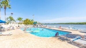 A pool area with lounge chairs and palm trees. - 215 Little Harbor Inn (Ruskin)