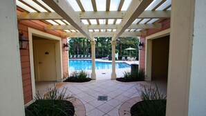 En overdækket patio med swimmingpool, komplet med pergola og plantekasser.