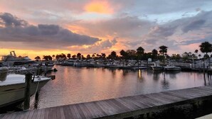 A marina with boats docked, a wooden dock, and a sunset sky. - 464 Little Harbor (Ruskin)