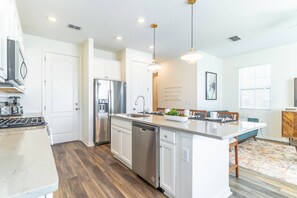 Enjoy cooking in the well-equipped kitchen with a central island, stainless steel appliances, and ample cabinetry.