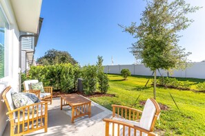 Enjoy dining or relaxing in this patio area with a table and chairs.
