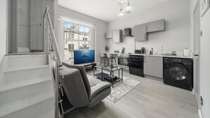 Eine moderne Wohnung mit Wohnzimmer, Küche und einem Balkon.