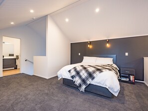 Une chambre à coucher moderne avec un lit, une table de chevet et une bibliothèque.