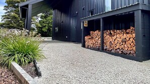 A modern building with a gravel driveway and a covered outdoor area. - Mangawhero River Chalet (Ohakune)