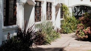 A white building with multiple windows and a covered walkway. - Miraverde Pinamar (Pinamar)